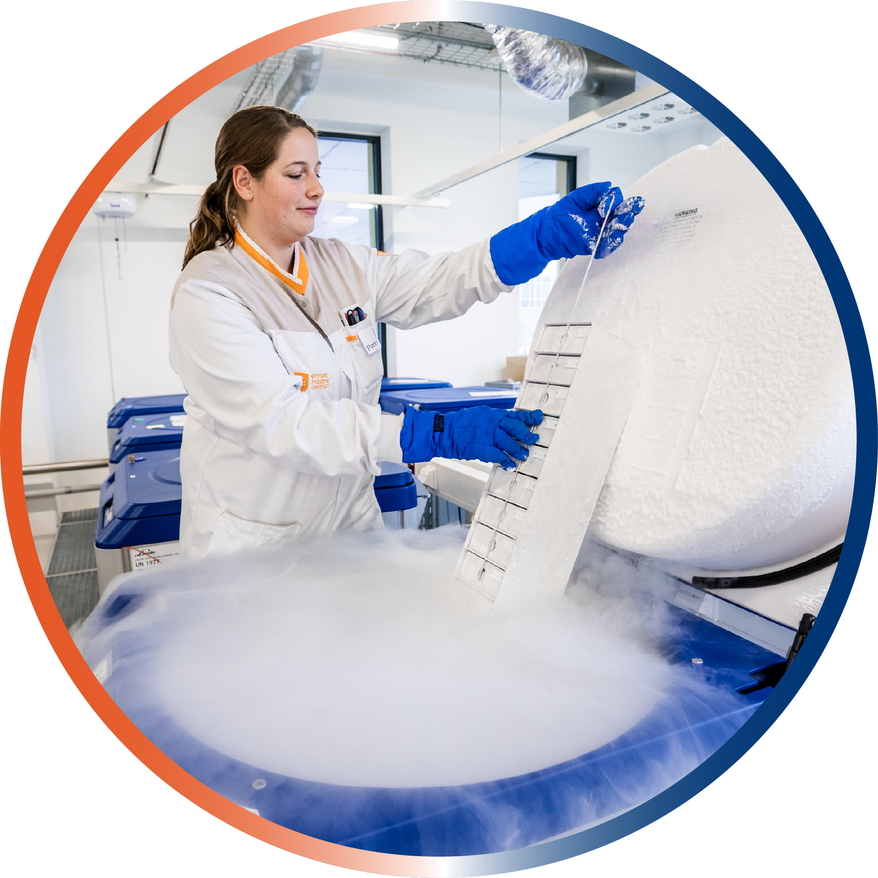 Biobank staff with lab coat and gloves pulling a sample rack out of a tank with liquid nitrogen. (c) Princess Máxima Center.