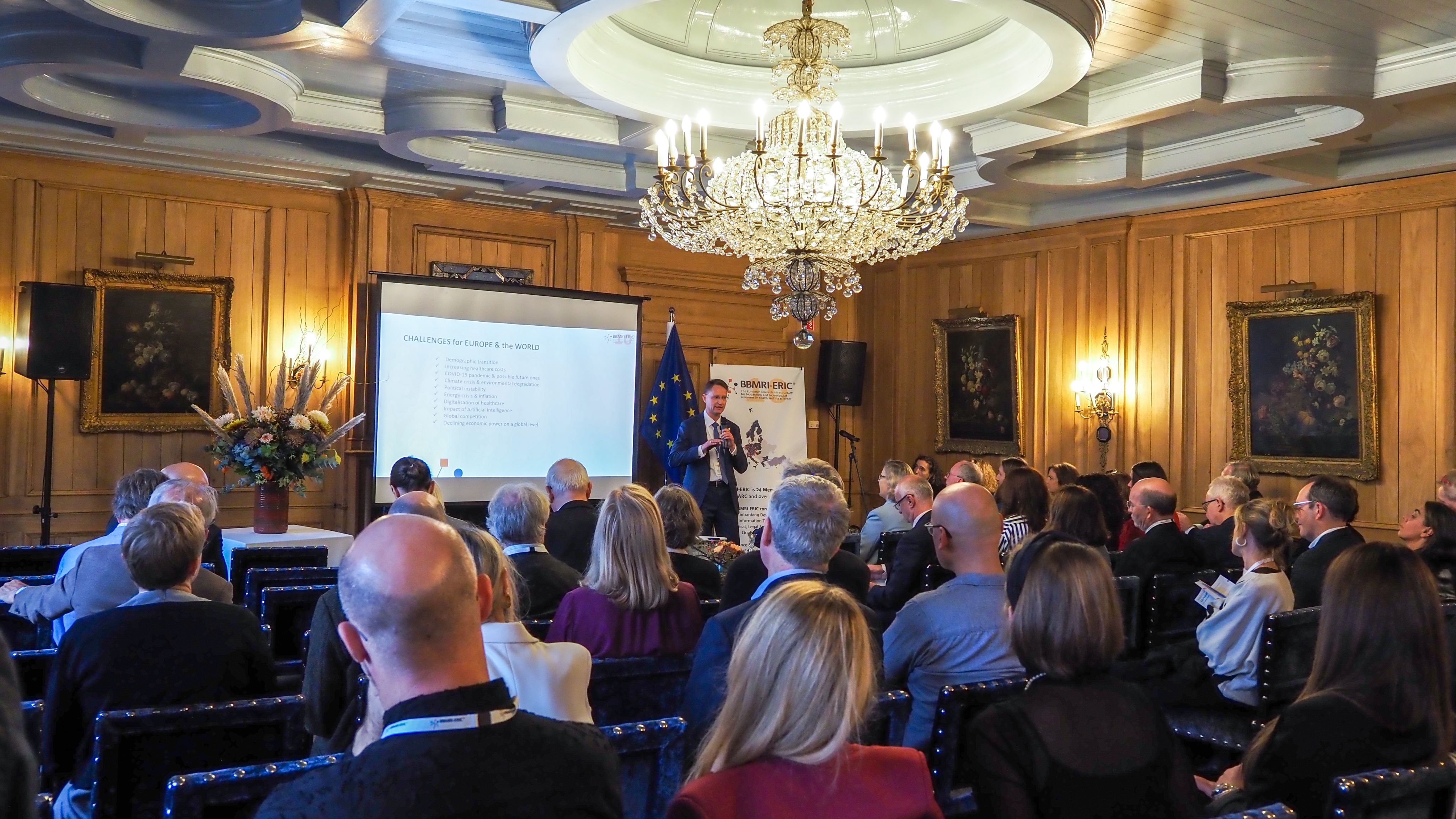 The picture of a man wearing a suit presenting to an audience.