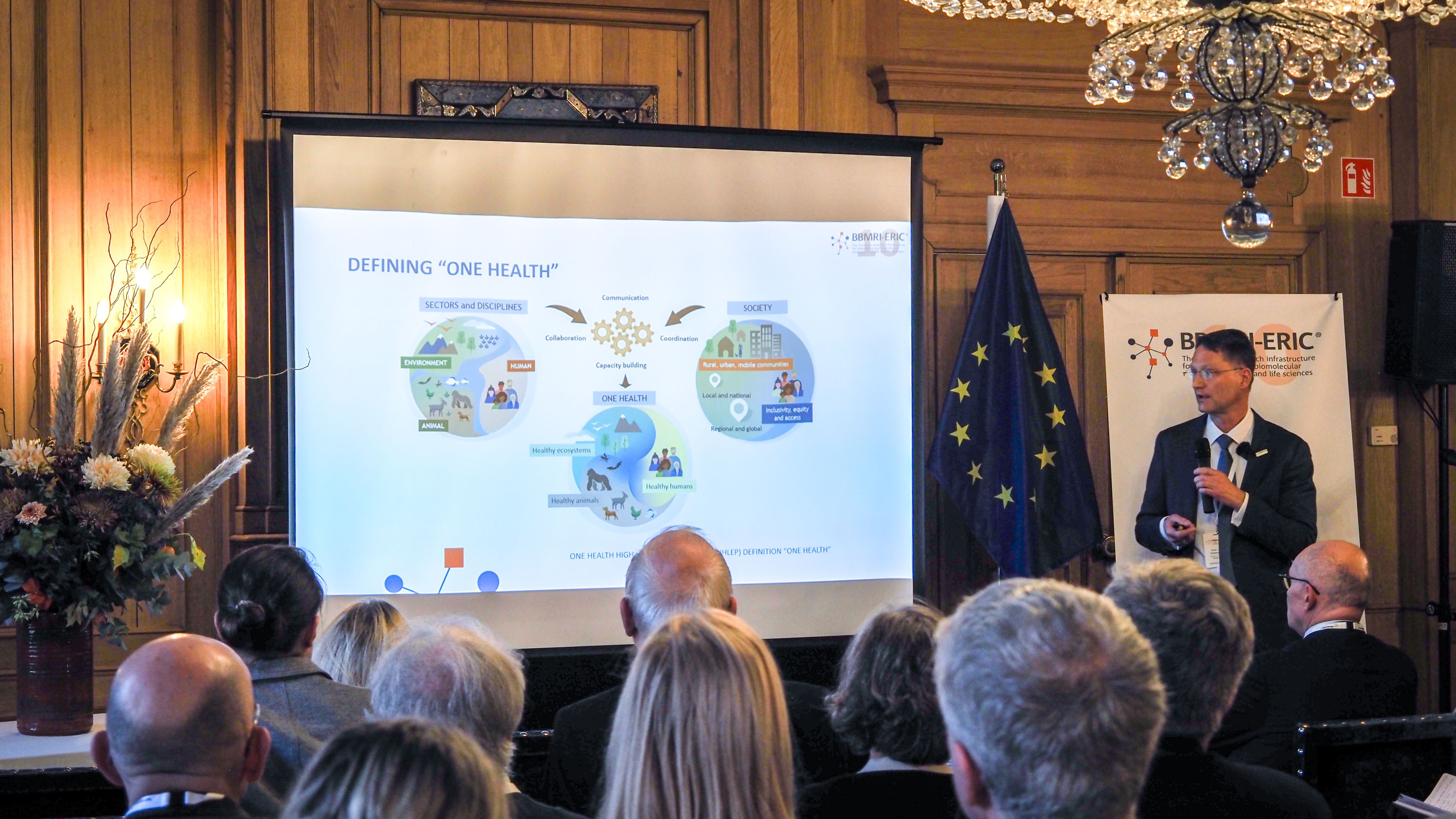 The picture of a white man presenting to an audience