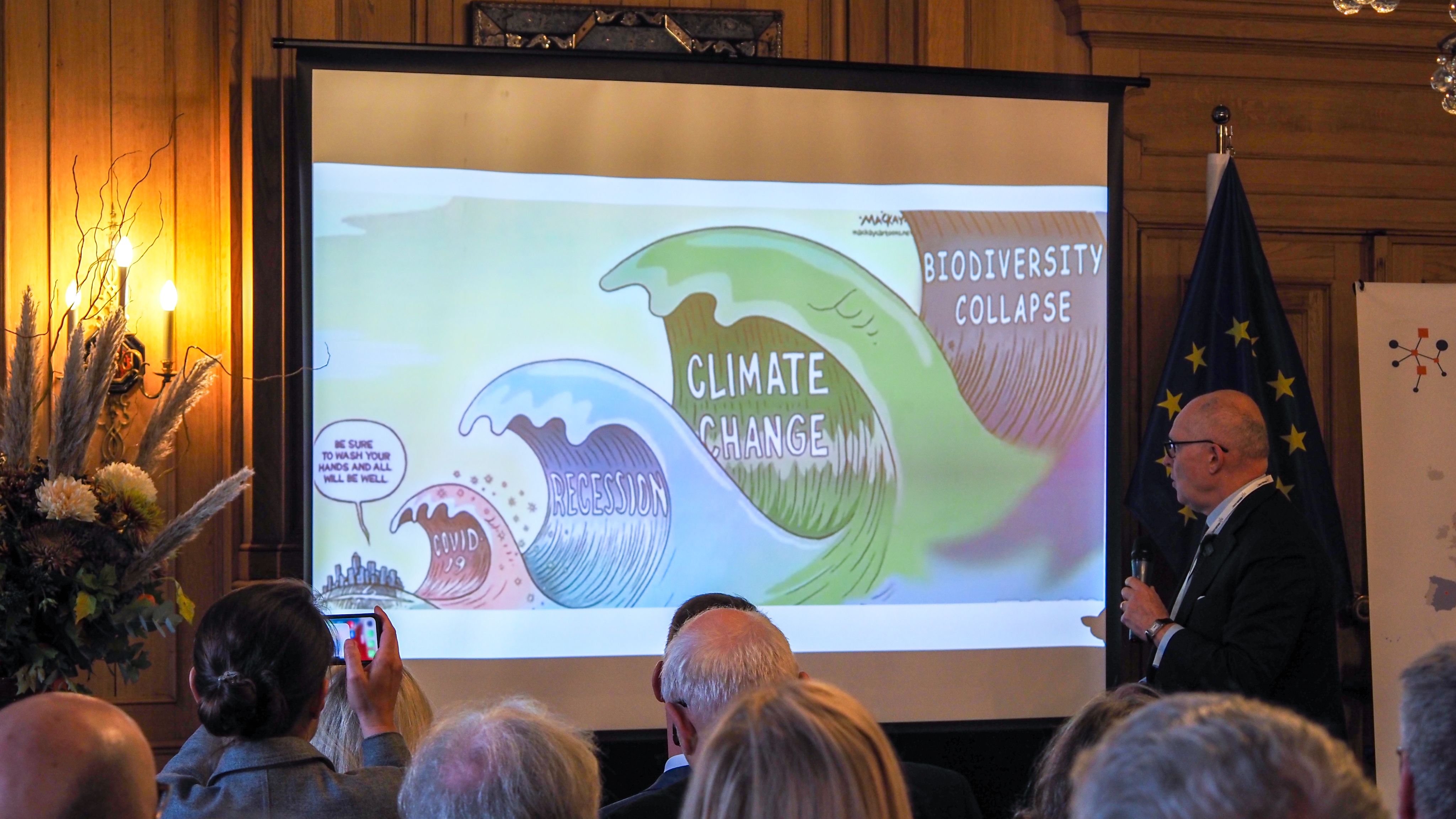 The picture of a man presenting to an audience. 