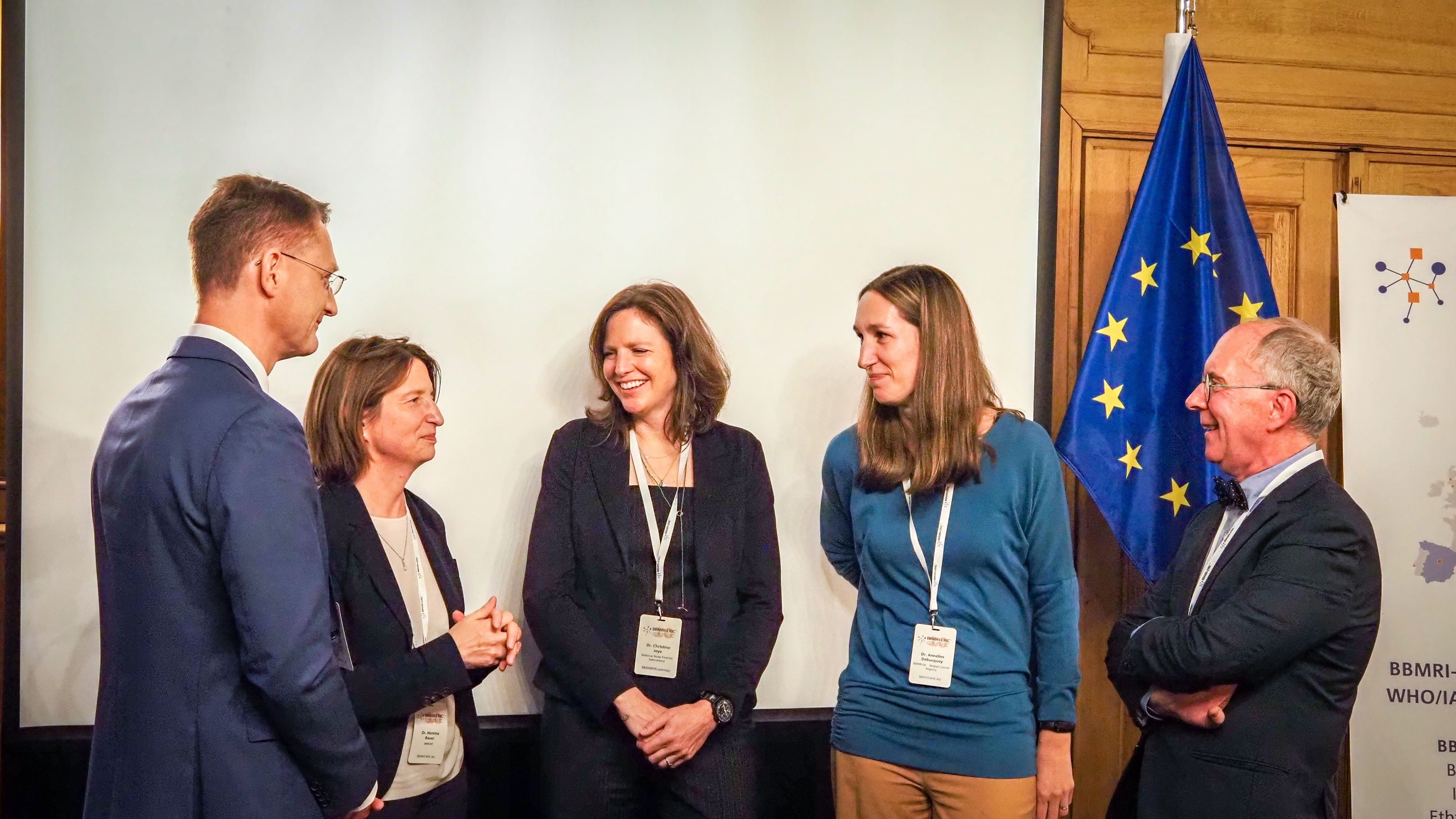 A picture representing a group of people talking to each other and smiling