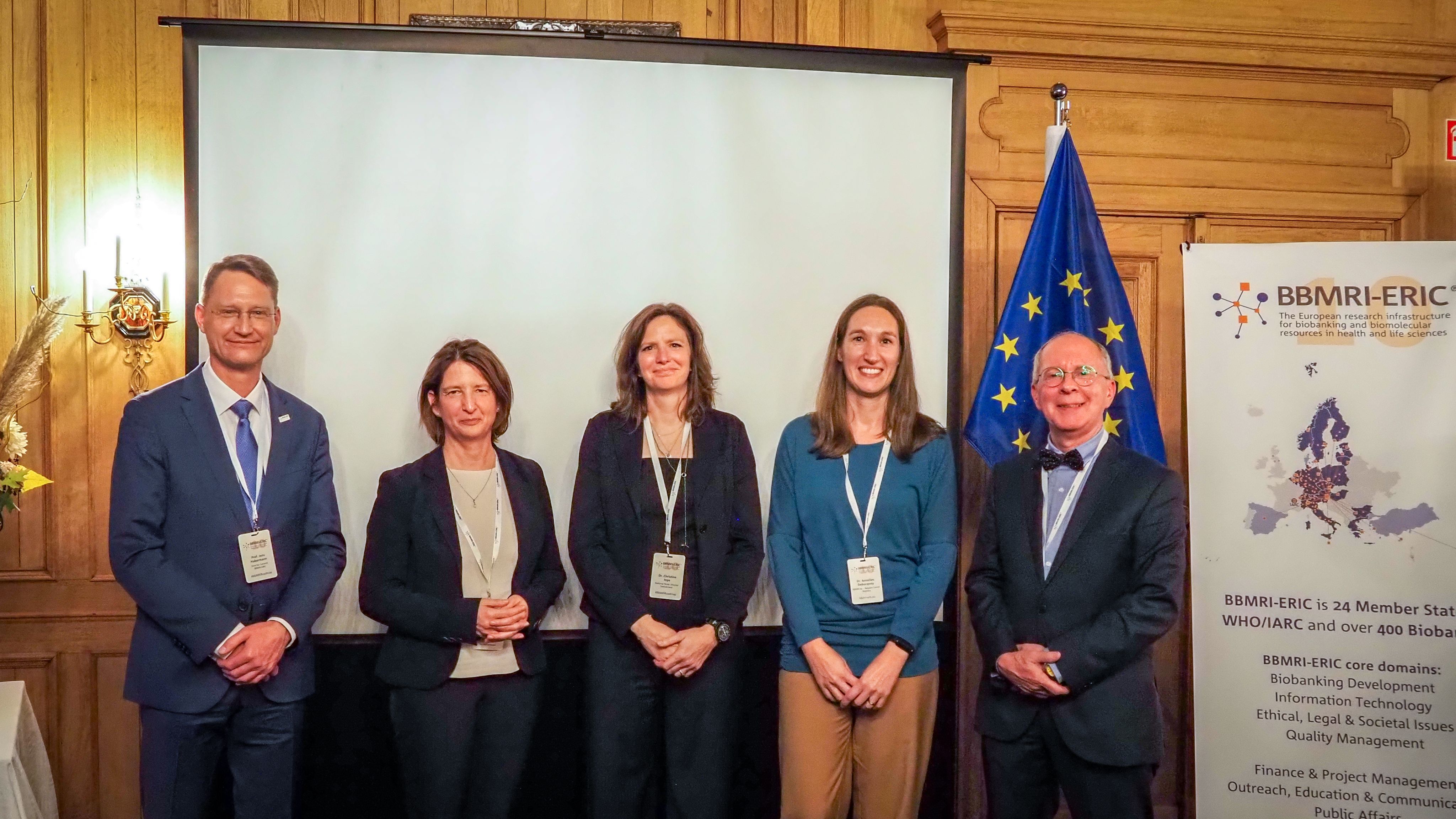 A group picture of people wearing formal suits and smiling at the camera.
