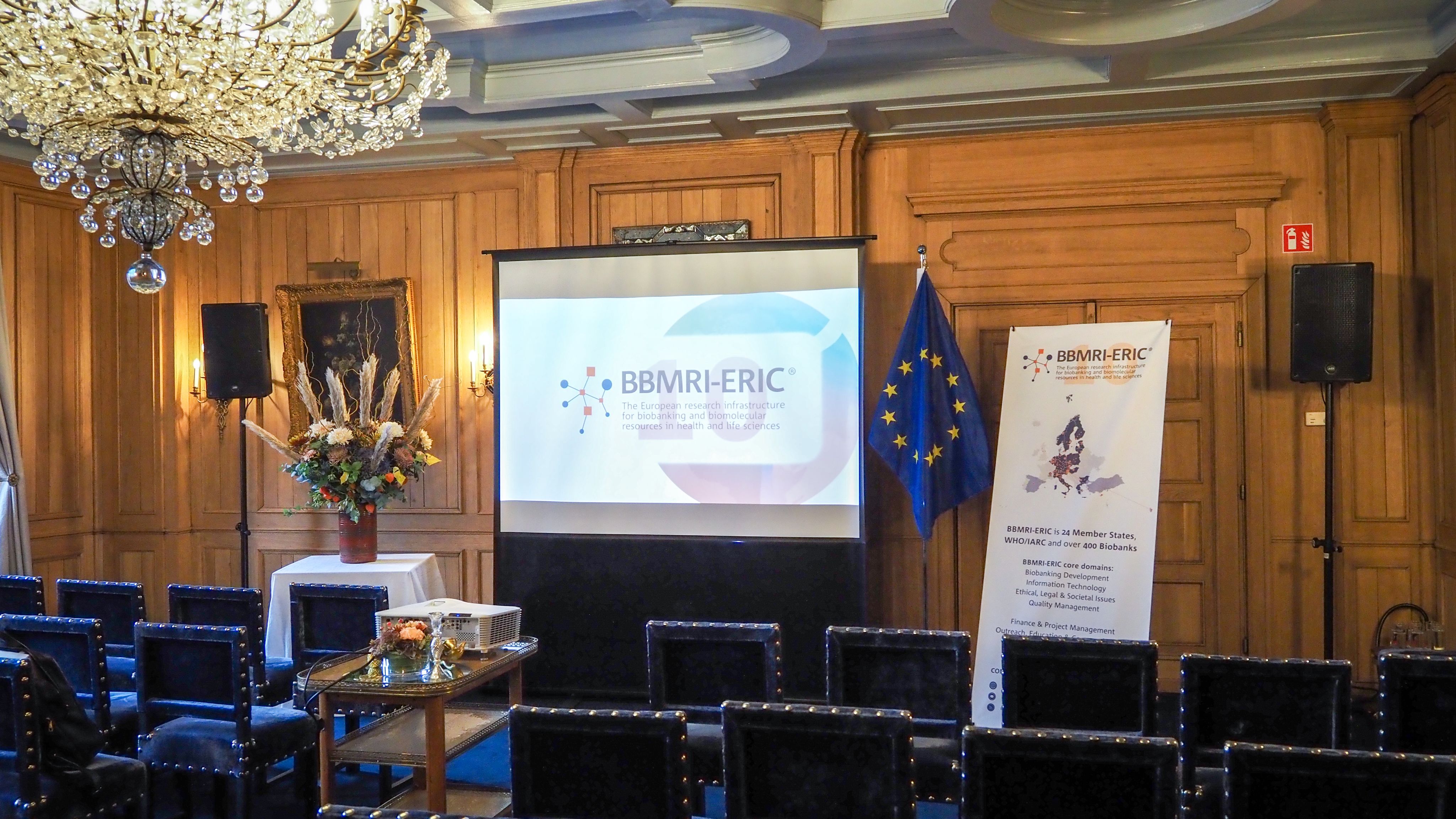 The picture of a meeting room with the BBMRI-ERIC logo