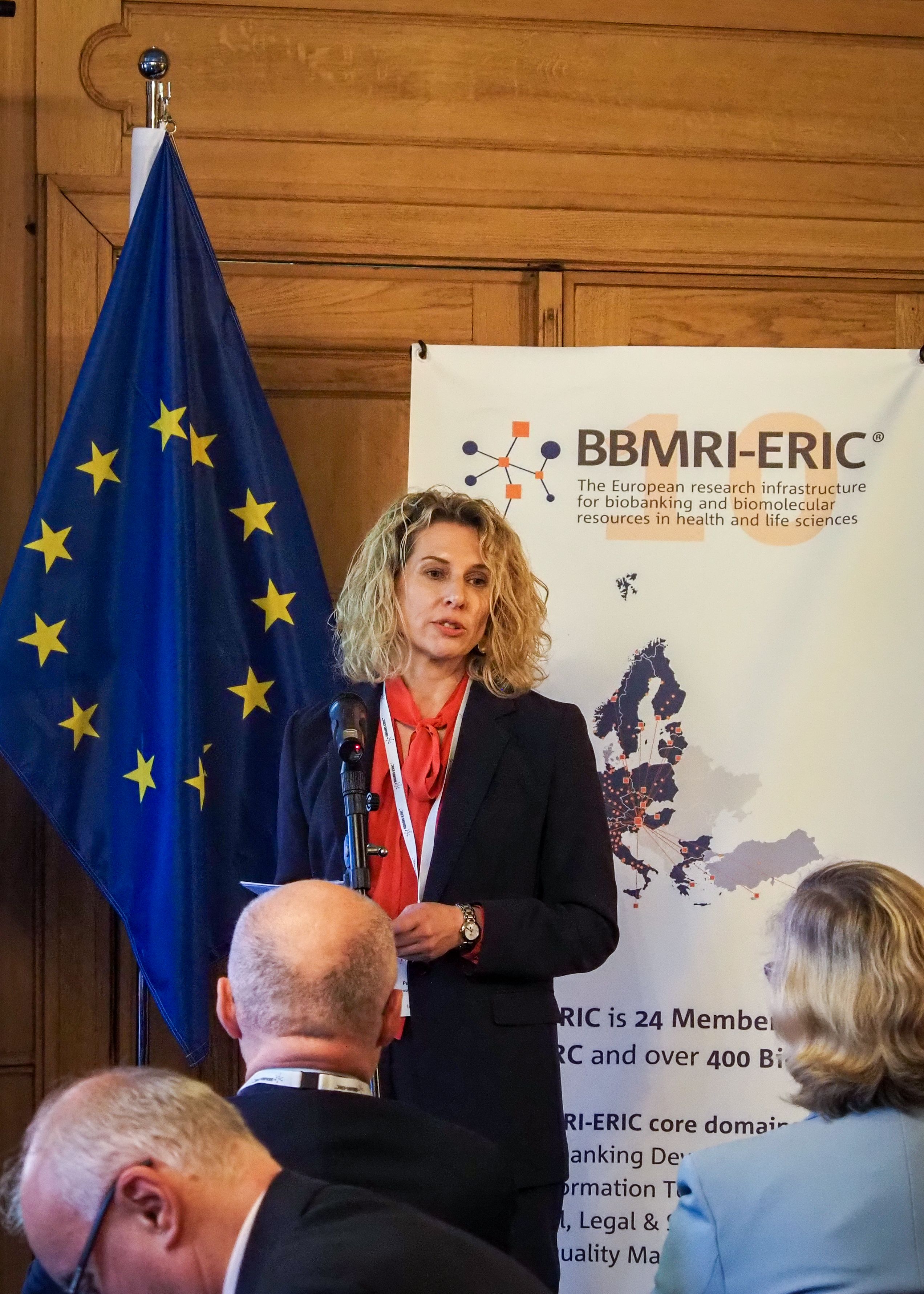 The picture of a white blonde woman speaking to an audience. 