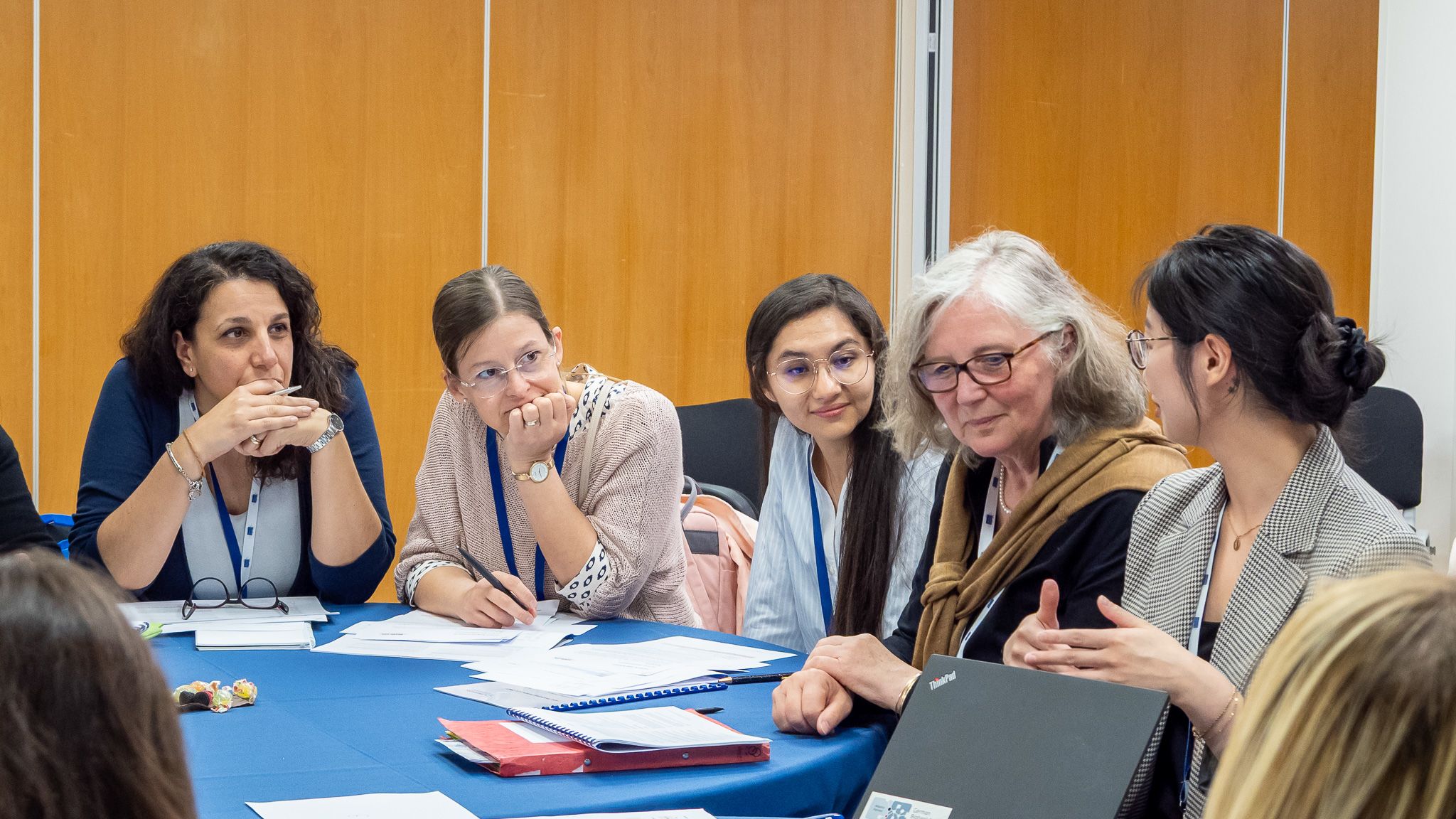 A group of women at a conference table during a vivid discussion as part of a workshop.
