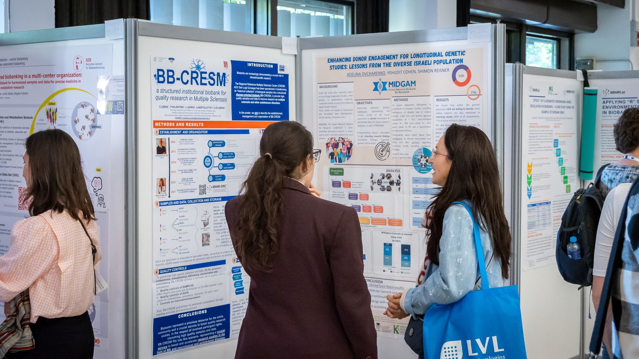 Two women standing in front of a poster discussing the content.